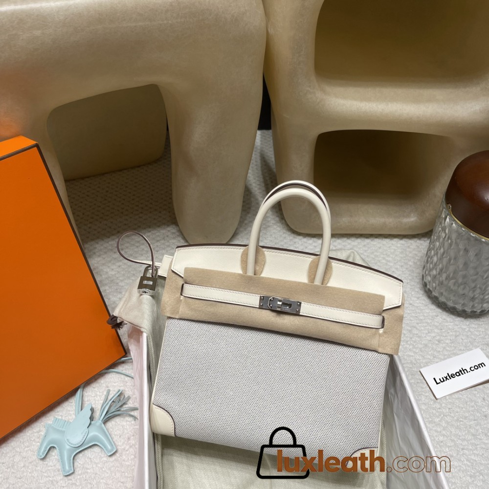 Hermès Birkin 25 (Triomphe H Canvas & Swift Leather) – Color: I2/Nata (with Silver Hardware) – A soft cream-white hue – This model is characterized by a combination of high-quality Swift leather and lightweight canvas. The natural cream-white color create